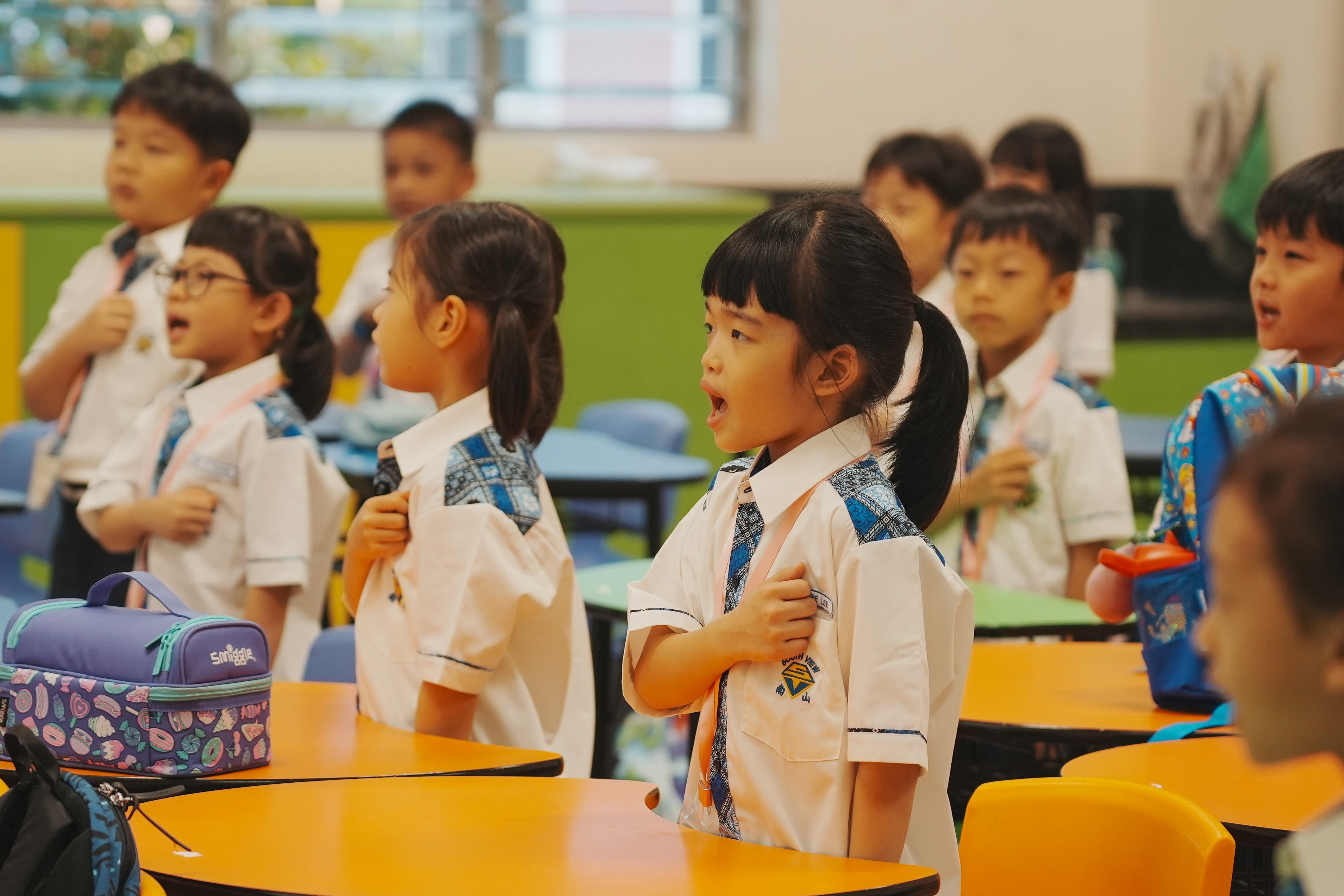Picture of students doing pledge during assembly period in classroom